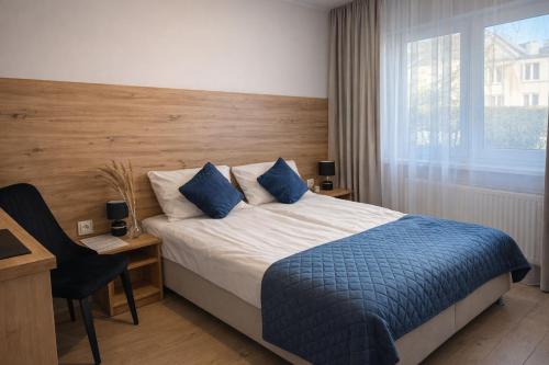 a bedroom with a bed and a desk and a window at New Corner Apartamenty in Niechorze