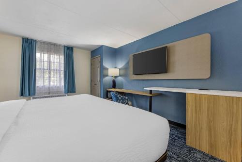 a bedroom with a large bed and a tv at Sleep Inn & Suites Merrillville in Merrillville