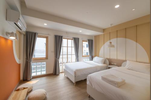 a hotel room with two beds and a window at Tungyu Home Old Town - 1 min to walking street in Chiang Mai