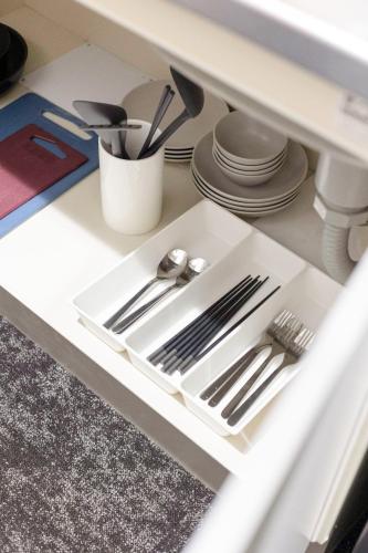 a drawer with silver utensils in a cabinet at b&今里店 in Osaka