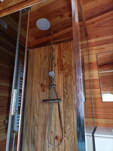 a shower in a room with wooden walls at Glamping Dôme Benzène in Fonmourenne