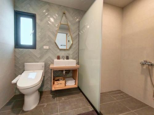 a bathroom with a toilet and a sink and a mirror at 杉灣小徑民宿 in Xiaoliuqiu