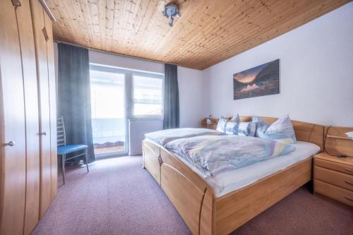 a bedroom with a bed and a large window at Gästehaus Jutta in Lindberg