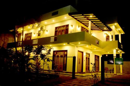 a large white house at night with lights at Abey Villa Madiha Beach Surf Stay in Matara