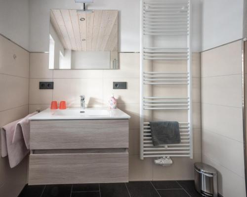 a bathroom with a sink and a mirror at Gästehaus Jutta in Lindberg