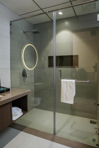 a bathroom with a shower with a glass door at King's Kraft Shubh Hotel in Dwarka