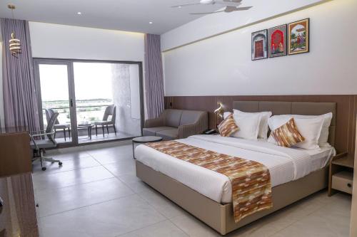 a hotel room with a bed and a balcony at King's Kraft Shubh Hotel in Dwarka