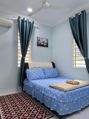 a bed in a room with blue walls and windows at Che Puan Homestay Baling - 2 unit house with kids pool in Baling