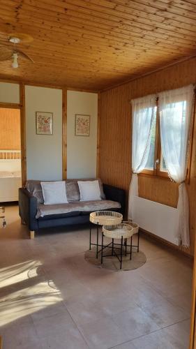 a room with a bed and two tables in it at Les Chalets de la Besbre in Jaligny