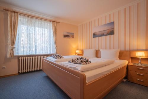 a bedroom with two beds and a large window at Kim im Haus Wega in Westerland