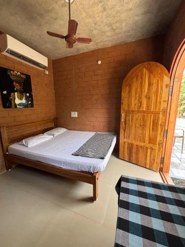 a bedroom with a bed and a wooden cabinet at Auro Waves Rooms & Hostel in Auroville