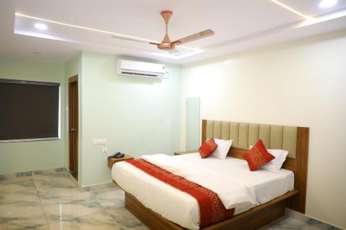 a bedroom with a bed with a ceiling fan at Hotel PR Royal in Bhīmavaram