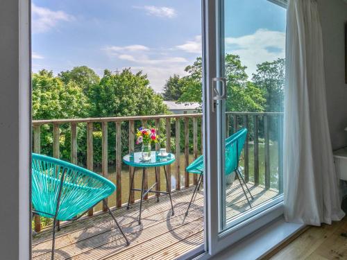 a balcony with two chairs and a table with flowers on it at Riverside in Stone