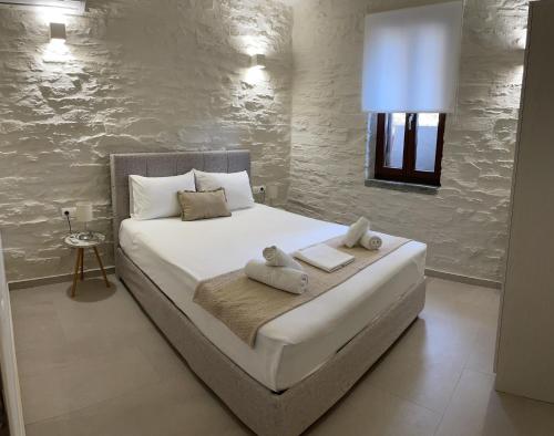 a bedroom with a white bed with towels on it at Villa Cavo d' Oro in Korissia