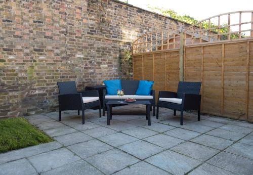 a patio with chairs and a table with blue pillows at Charming Tower Bridge Apartment in London