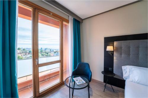 ein Hotelzimmer mit einem Bett, einem Stuhl und einem Fenster in der Unterkunft Abba Garden in Barcelona