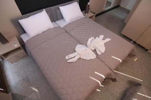 a large bed with two stuffed animals on it at Hotel Korzo in Bitola