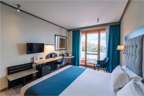 ein Hotelzimmer mit Bett und Schreibtisch mit Computer in der Unterkunft Abba Garden in Barcelona