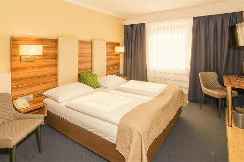a hotel room with a large bed and a desk at Hotel Kufsteinerhof in Kufstein