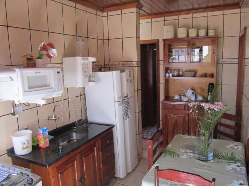 a kitchen with a refrigerator and a table in it at Casa em Paraty a 7 min. do Centro histórico in Paraty