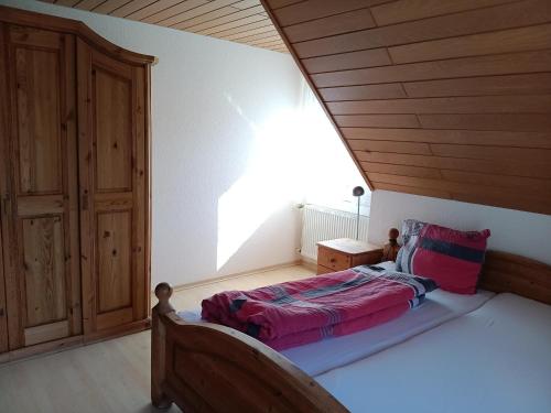 a bedroom with a bed with a wooden ceiling at Haus am Limes in Pfedelbach