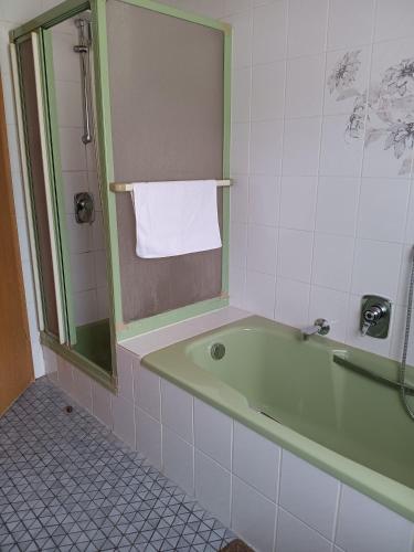 a bathroom with a green bath tub and a mirror at Haus am Limes in Pfedelbach