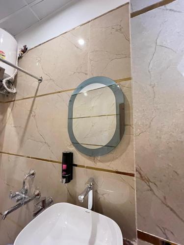 a bathroom with a mirror and a white sink at Hotel Shri Sai Palace Ayodhya in Faizābād