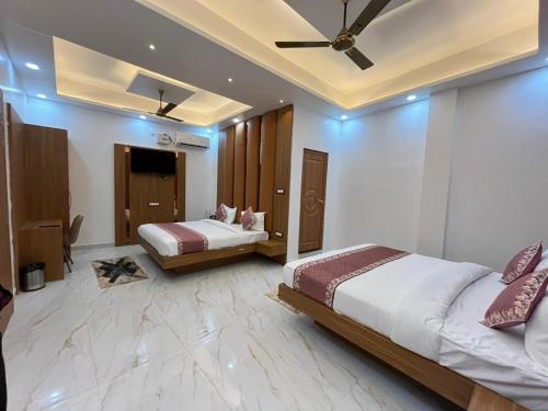 a bedroom with two beds and a ceiling at Hotel Shri Sai Palace Ayodhya in Faizābād