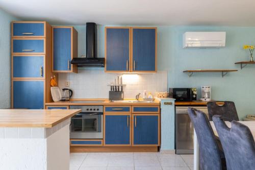 a kitchen with blue cabinets and a counter top at House Nešpula in Veli Lošinj