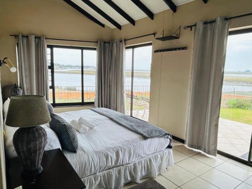 a bedroom with a bed and a large window at River Front Guest House in Gqeberha