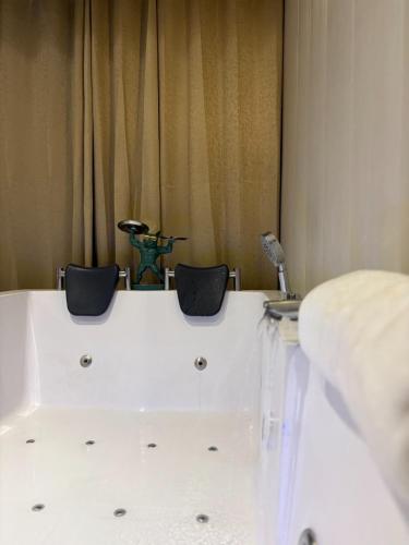 a white bath tub with two chairs in a room at Hotel Namaste With Jacuzzi I Best For Couples and Corporate I Noida in Noida