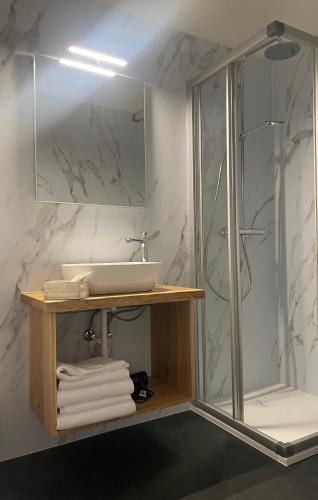 ein Badezimmer mit Waschbecken und Dusche inklusive Handtüchern in der Unterkunft Vecchia Mori in Mori