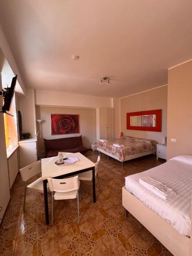 a room with two beds and a table and a bed at MONOLOCALI DA VINCI in Falconara Marittima