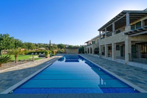 uma piscina em frente a um edifício em 5 bedroom Villa Rio with large private pool and hot tub, Aphrodite Hills Resort em Kouklia