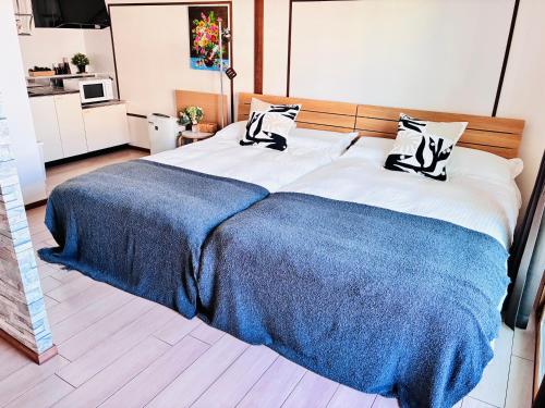 a bedroom with a large bed with a blue blanket at 蓮子川Room in Hamamatsu