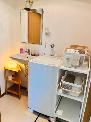 a bathroom with a sink and a small refrigerator at 蓮子川Room in Hamamatsu