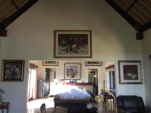 a bedroom with a bed and paintings on the wall at Singa Villas in Ungasan