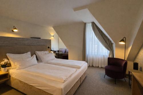 a hotel room with a bed and a window at DORMERO Aparthotel Stralsund in Stralsund