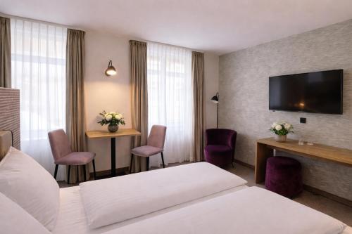 a hotel room with a bed and a tv at DORMERO Aparthotel Stralsund in Stralsund