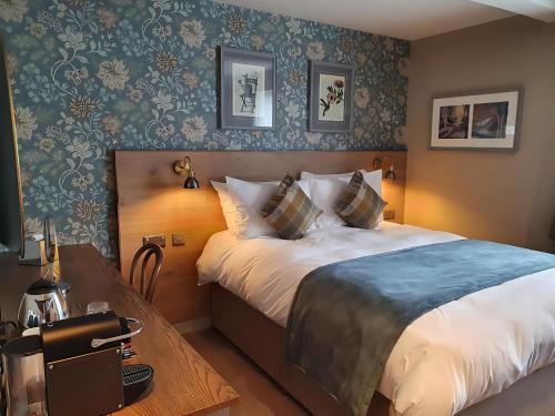 a bedroom with a large bed and a table with a phone at Old Swan in Skipton