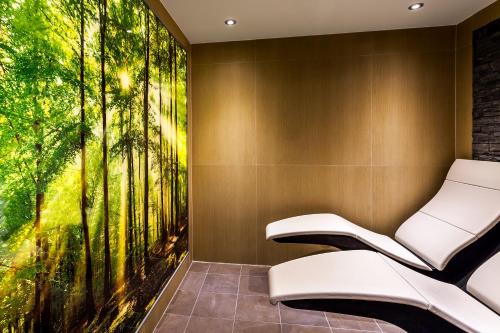 a bench in a room with a large mural of trees at Langdale Hotel & Spa in Ambleside