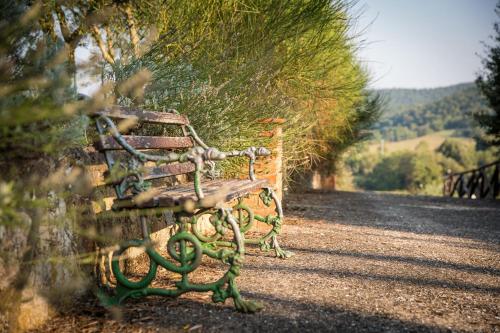 a bench sitting on the side of a road at Borgo Il Poggiaccio Residenza d'Epoca in Sovicille