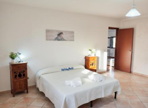 a bedroom with a white bed and a table at Casa Gioele by Holiday World in Bove