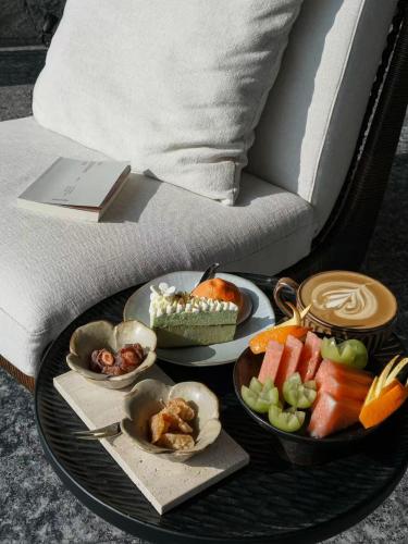 a tray with plates of food on a table next to a couch at Arcadia anyin qingshan hotel in Dali Shuanglang