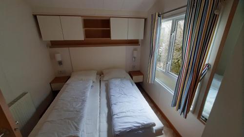 a small room with two beds and a window at Luiwagen in Raalte
