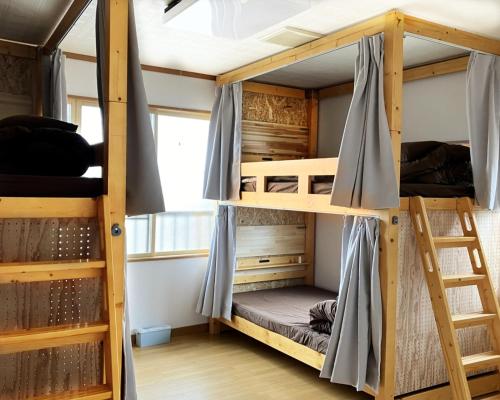a room with bunk beds in a hostel at ゲストハウスわたうさぎ in Tsuruoka