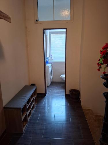 a bathroom with a toilet and a window and a bench at Apartmán u parku in Prostějov