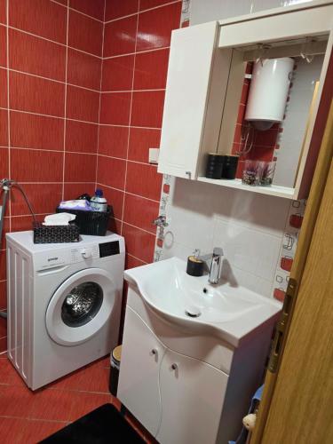 a bathroom with a washing machine and a sink at Apartman Anja'K in Doboj
