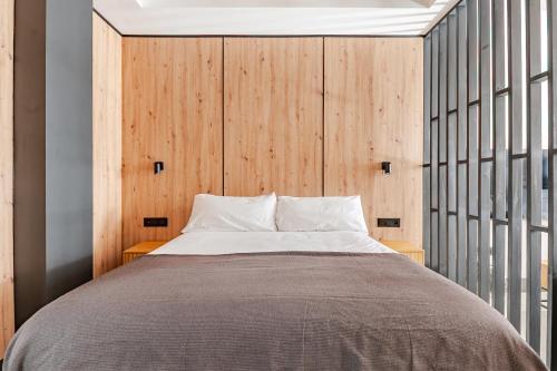 a bedroom with a bed and a wooden wall at Elcano Suites in Seville