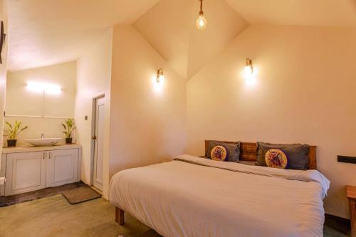 a bedroom with a large bed and a sink at Outside Space Resorts in Lovedale